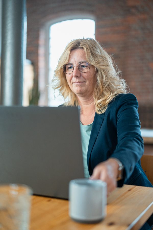 Schwebewerk Teammitglied Sarah mit Kaffee am Laptop