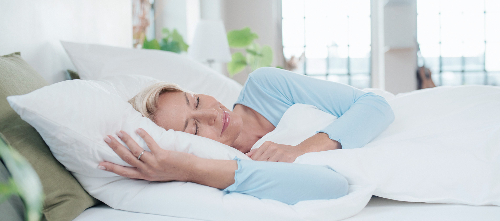 Frau schläft gesund und glücklich auf ihrer Matratze