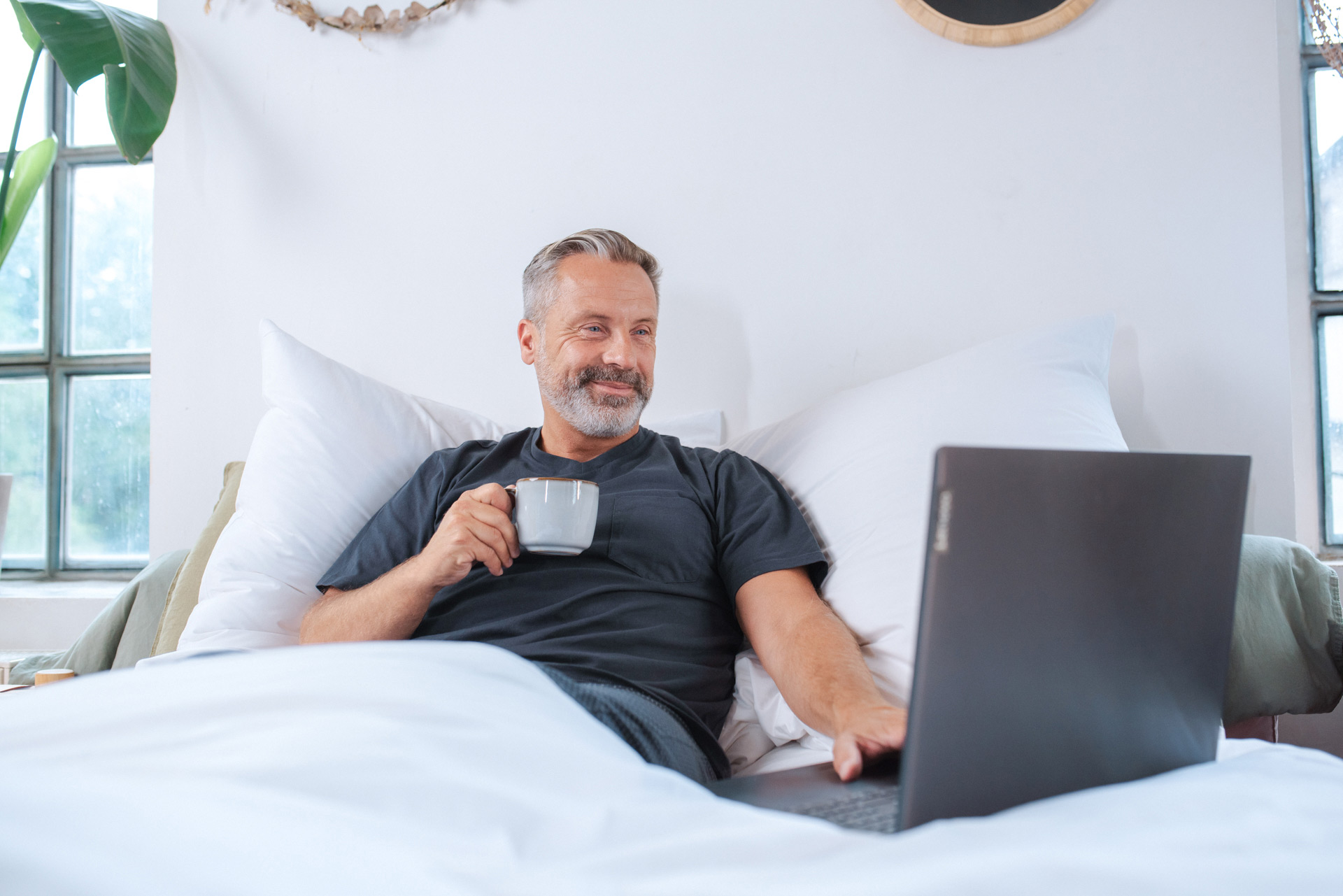 Gesunder Mann mit Laptop und Kaffee