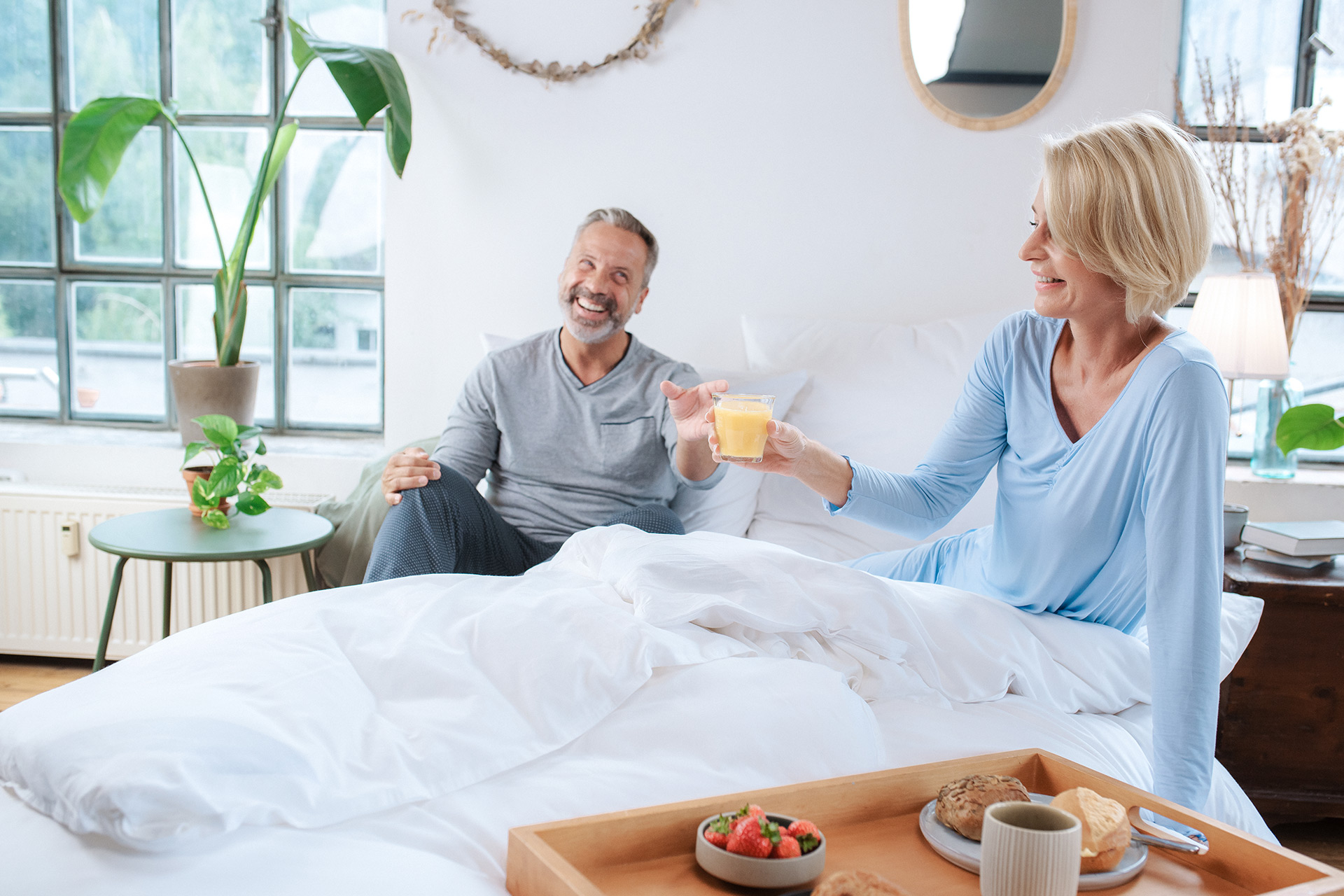 Mann und Frau frühstücken im Bett