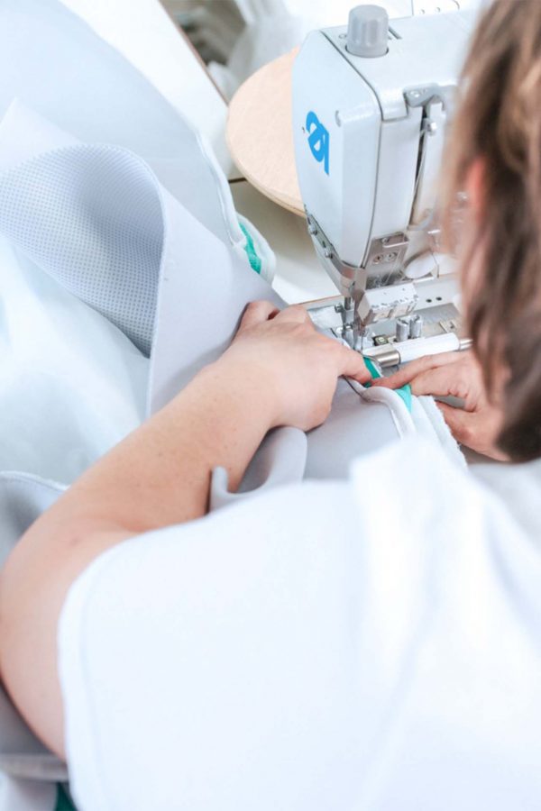 Schwebewerk-Mitarbeiterin näht einen Reissverschluss dran